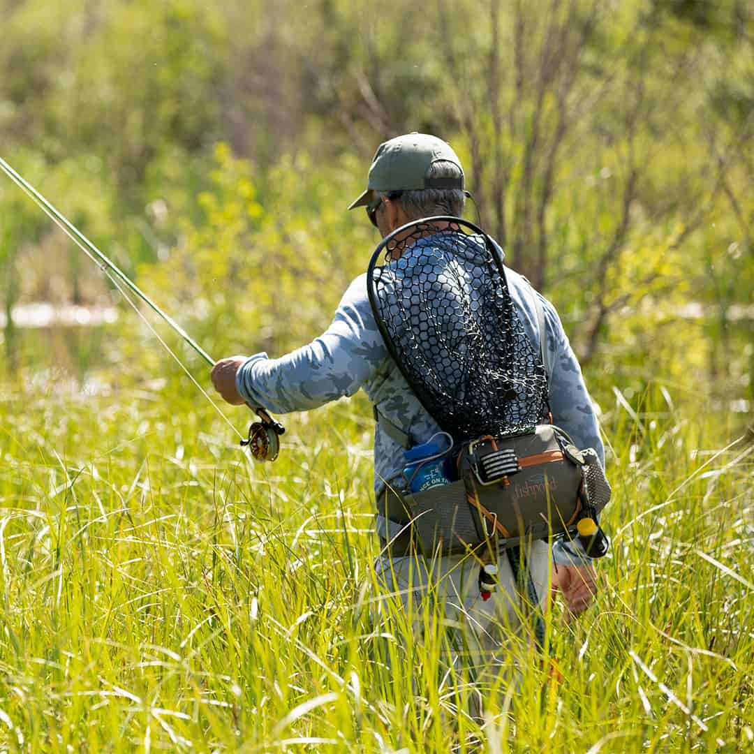 816332015694 EHLP-P Fishpond Elkhorn Lumbar Pack Pebble New Fishpond Waist Pack Front Walking Through Grass