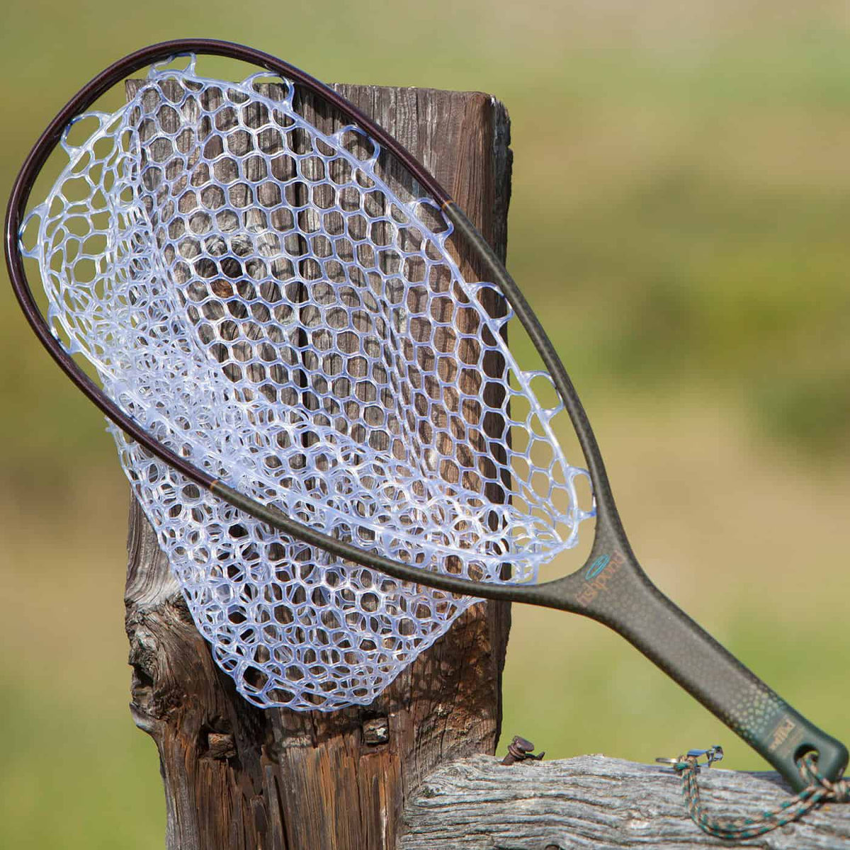 fishpond nomad native net native color outdoors on a fence next to a river