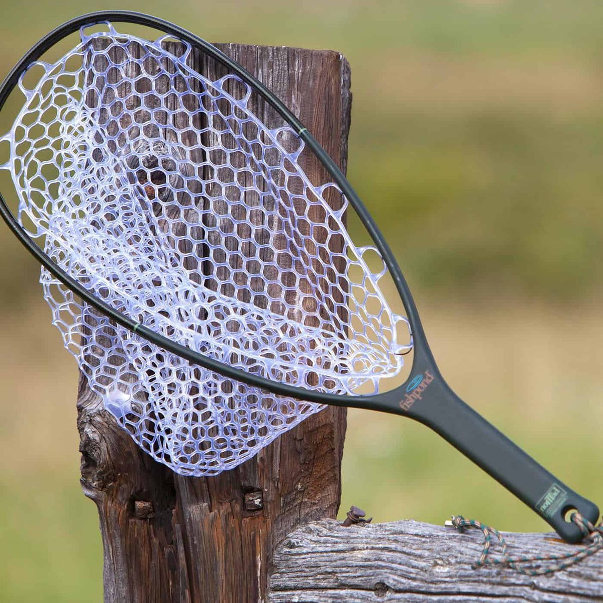 fishpond nomad native net outdoors on a fence next to a river